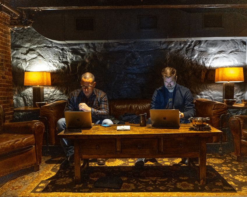 JASON AND JEFF AT THEIR LAPTOPS IN A DEN