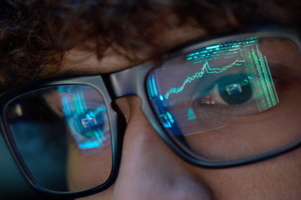 Person looking at a screen with stock charts on their glasses
