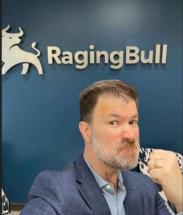 Jeff in front of a RagingBull sign