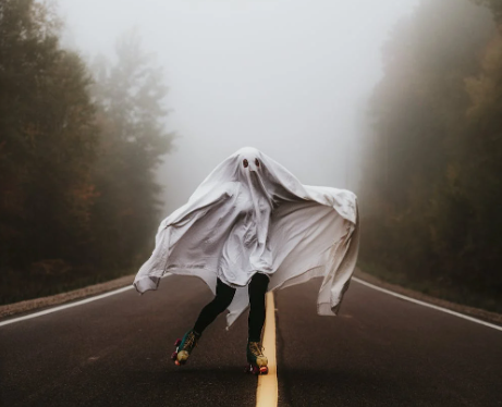 person in ghost costume running down the road