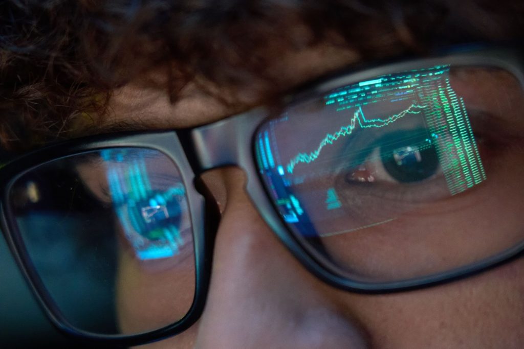 Person in glasses looking at stock charts
