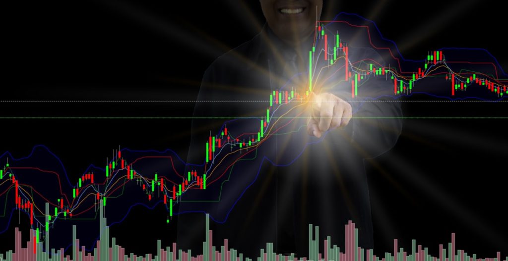 Person poitning a light at a stock chart
